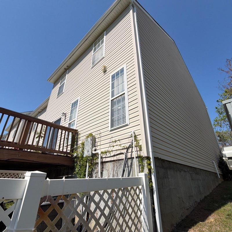 Vinyl siding and exterior house wall with deck and fence