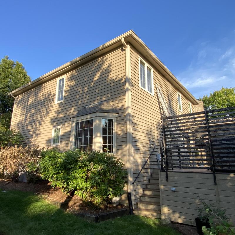 Gutters and gutter guards on beige siding home