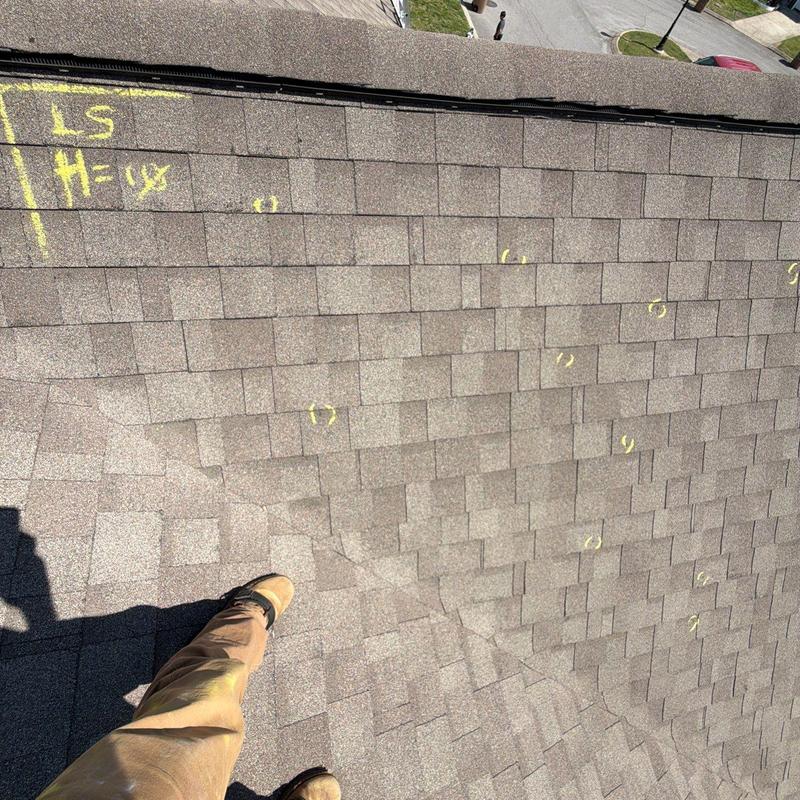 Roof shingles with hail damage markings on residential roof