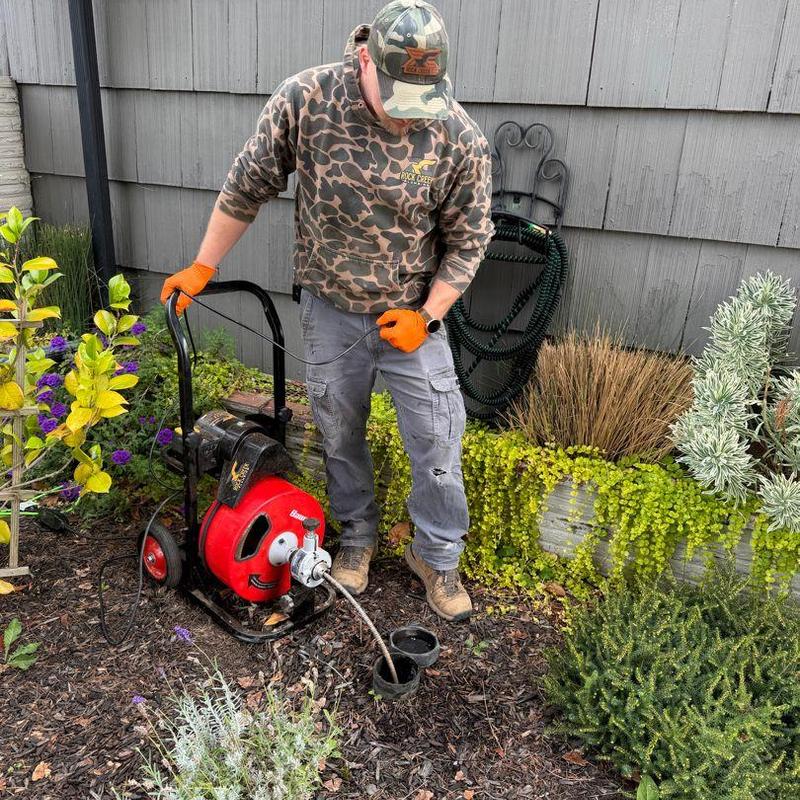 Main sewer line snake cleaning with drum machine outdoors
