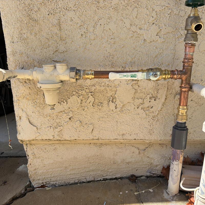 Water main valve and copper piping on exterior wall Water main valve and copper piping on exterior wall