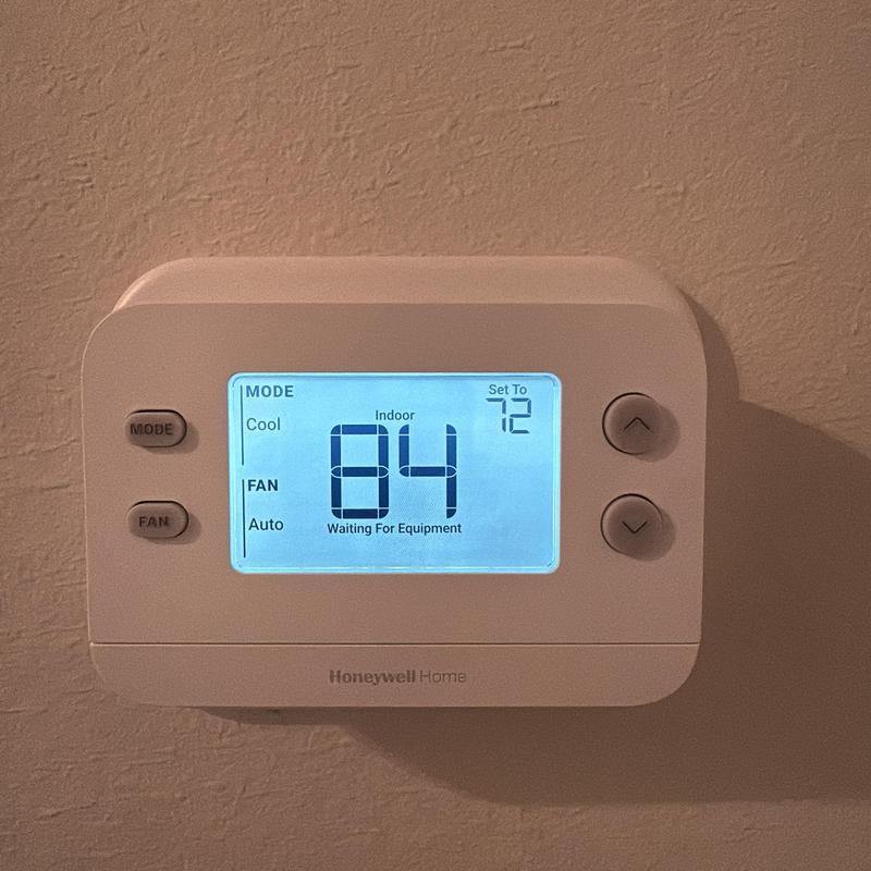 Thermostat display showing indoor temperature and settings Thermostat display showing indoor temperature and settings