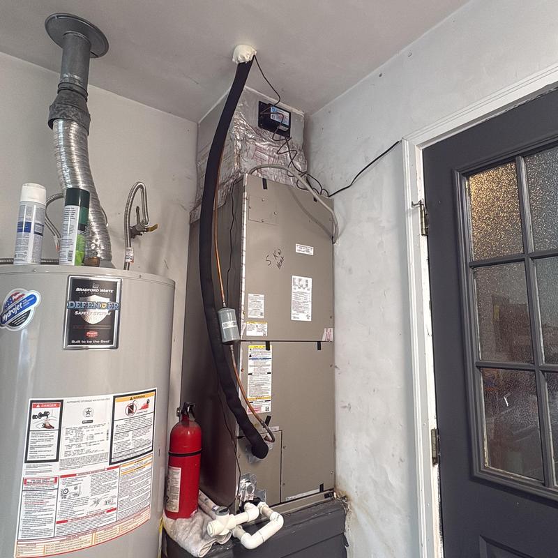Air handler unit with insulated refrigerant lines near water heater Air handler unit with insulated refrigerant lines near water heater