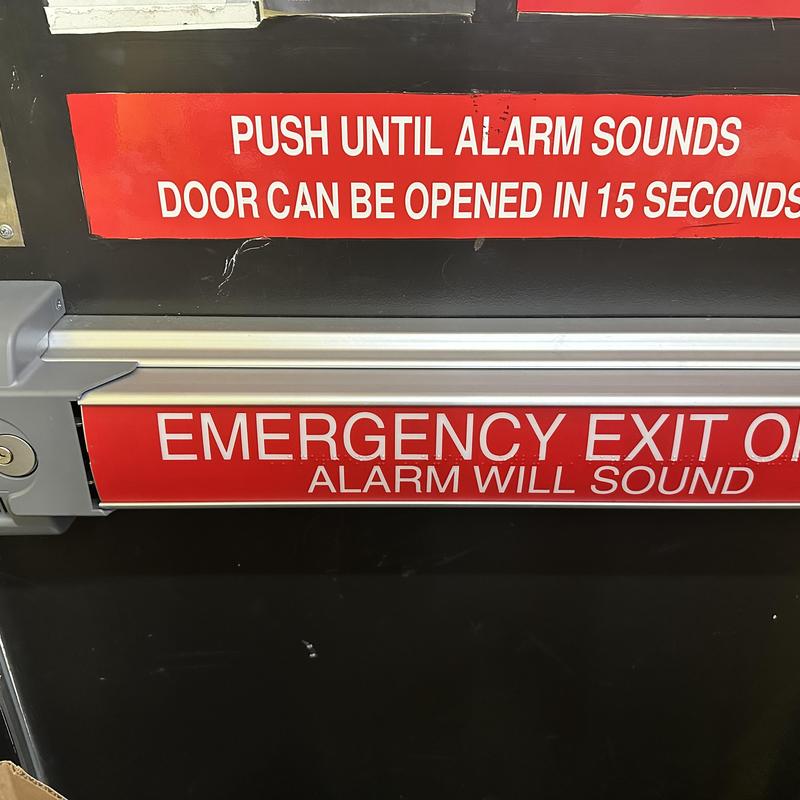 Emergency exit door panic bar with alarm signs Emergency exit door panic bar with alarm signs