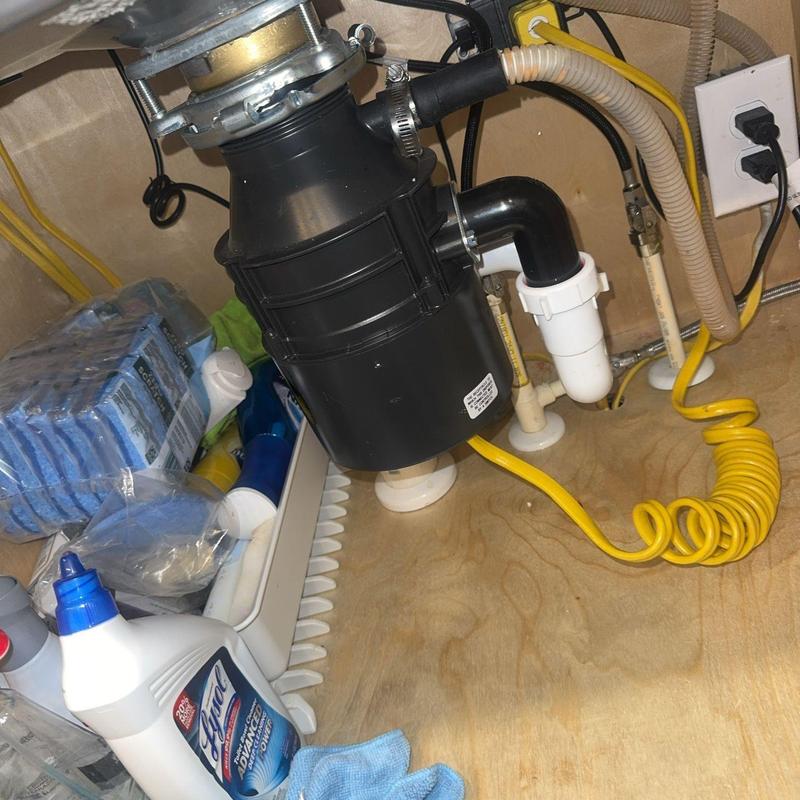 Garbage disposal unit with plumbing connections under sink Garbage disposal unit with plumbing connections under sink