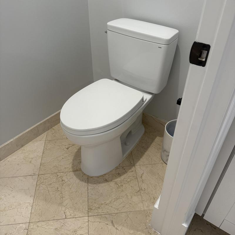 Toilet installation in guest bathroom with marble floor