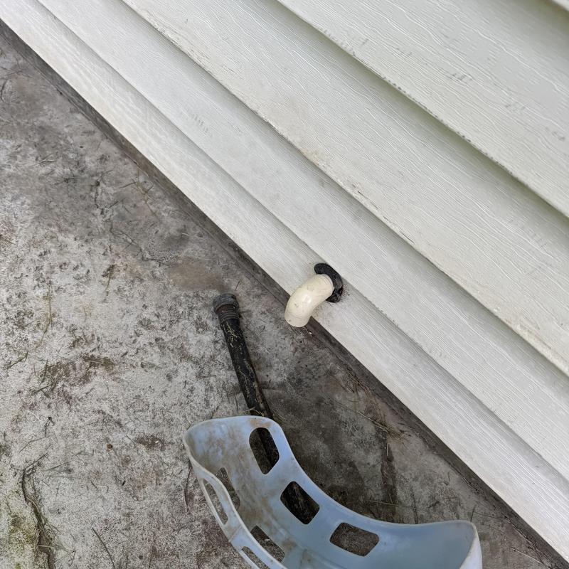 Water heater drain pipe and exterior wall siding panel Water heater drain pipe and exterior wall siding panel