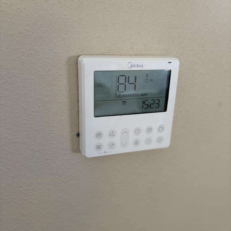 Midea thermostat displaying 84°F cooling mode Midea thermostat displaying 84°F cooling mode