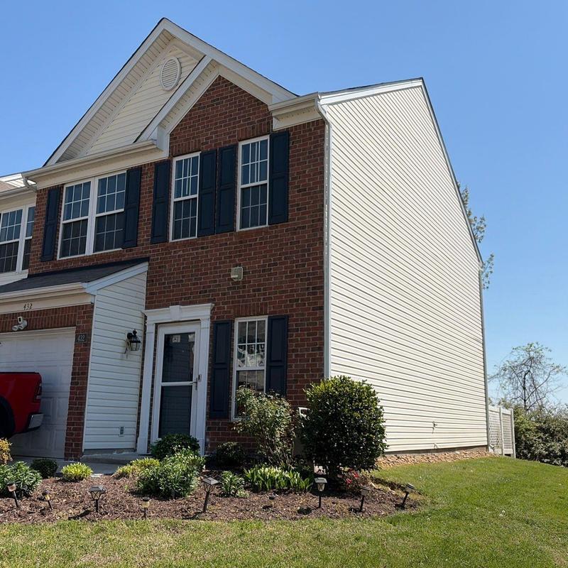 Roofing system exterior of townhouse with brick and siding