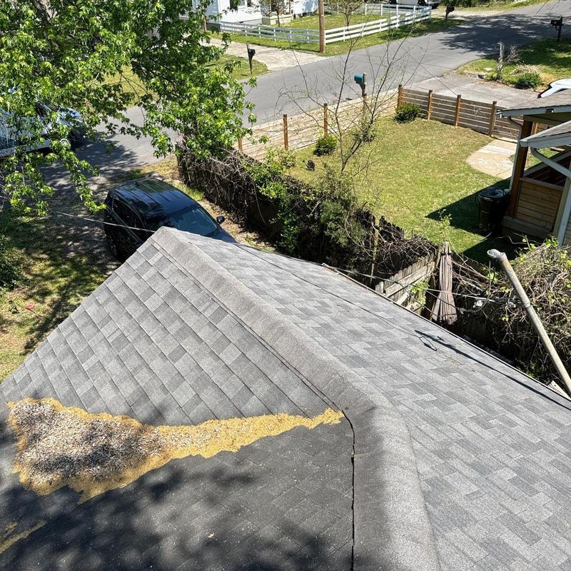 Roof shingles with debris and wear near ridge cap