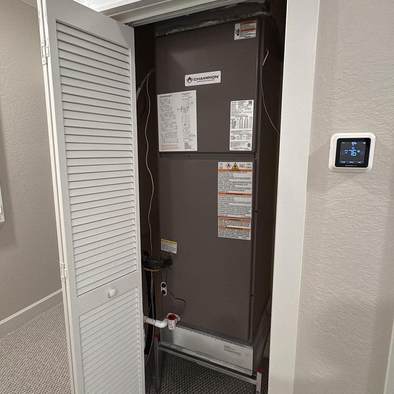 Champion HVAC air handler with wall thermostat in closet Champion HVAC air handler with wall thermostat in closet