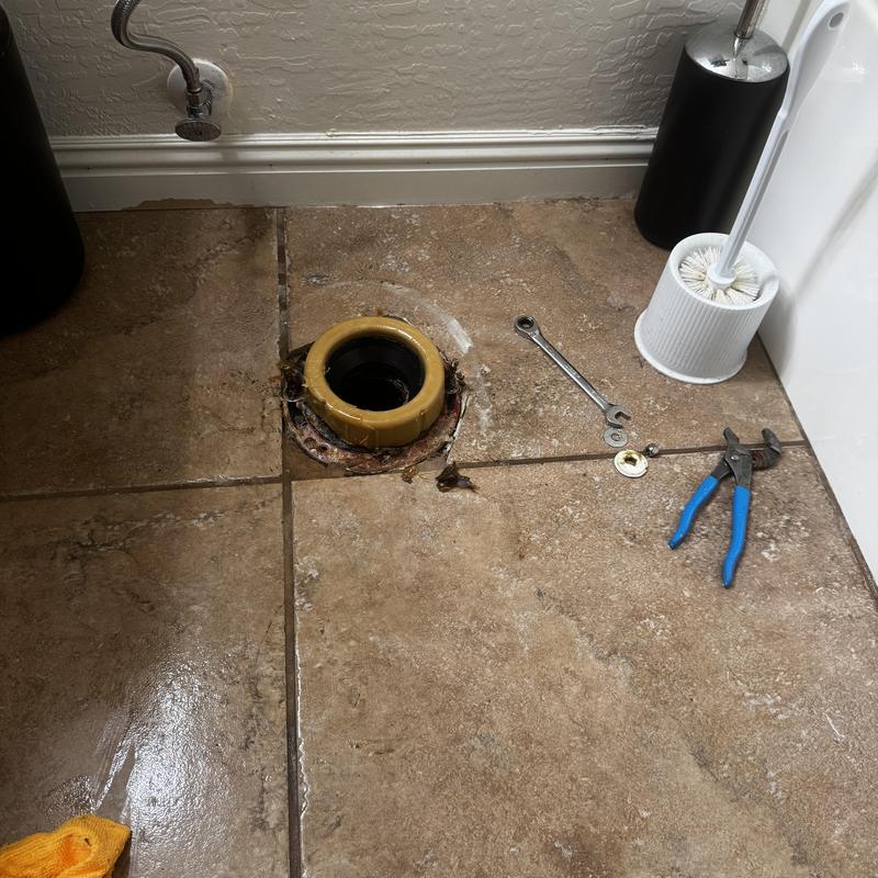 Toilet flange and drain with tools on tile floor Toilet flange and drain with tools on tile floor