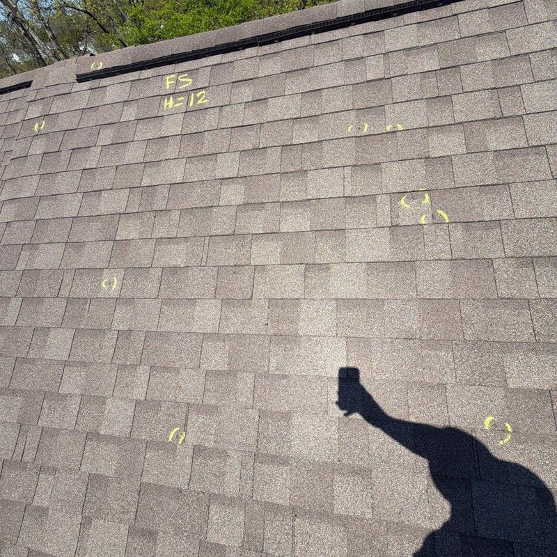 Roof shingles with yellow markings for hail damage inspection
