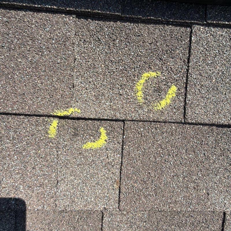 Asphalt shingle roof with yellow chalk hail damage marks