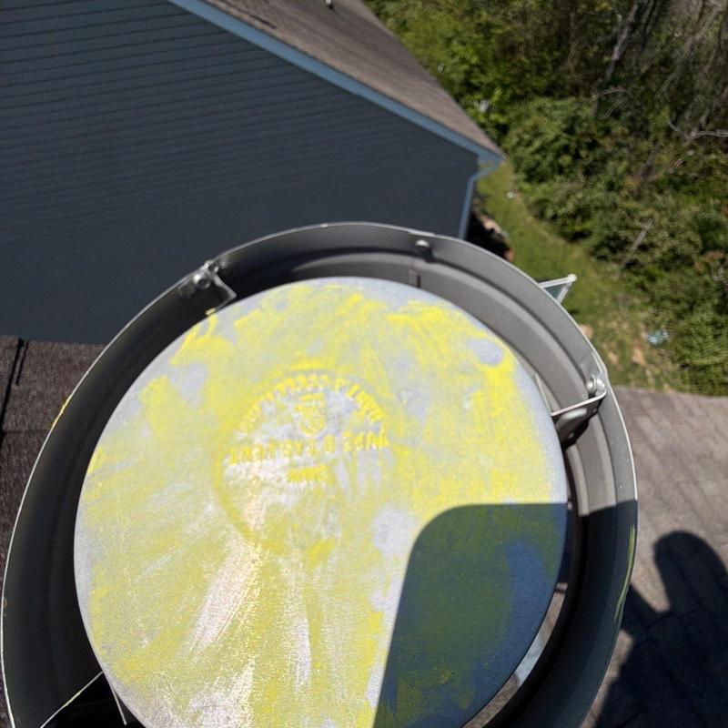 Roof vent cap showing hail damage on shingle roof