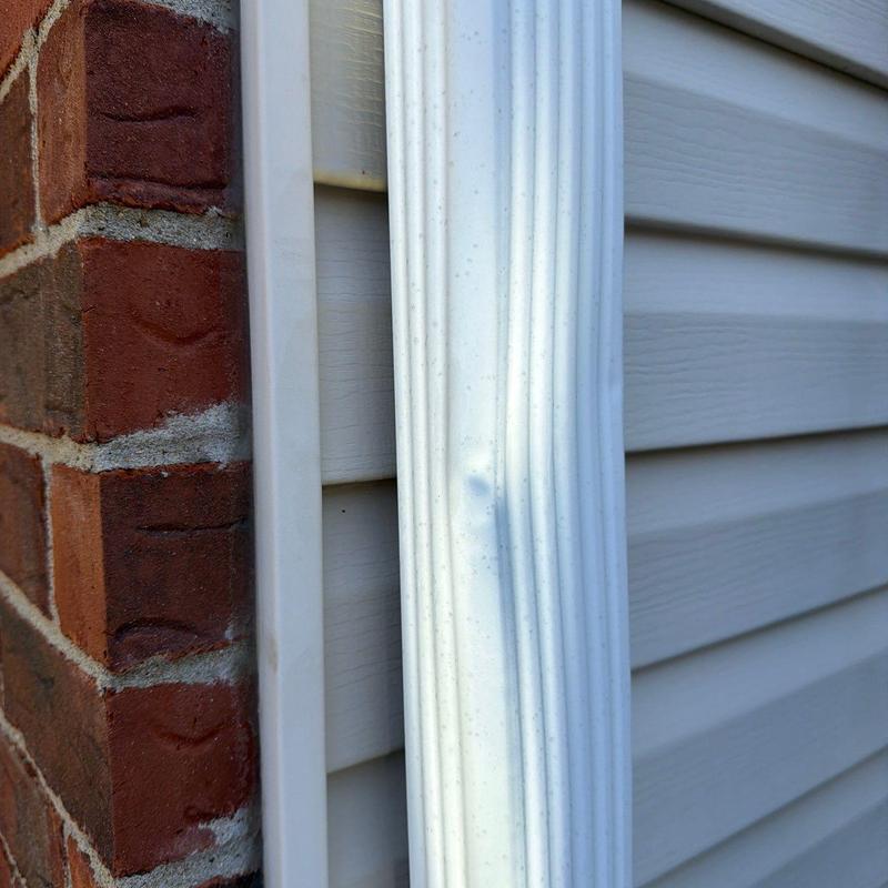 Vinyl downspout showing hail damage dents