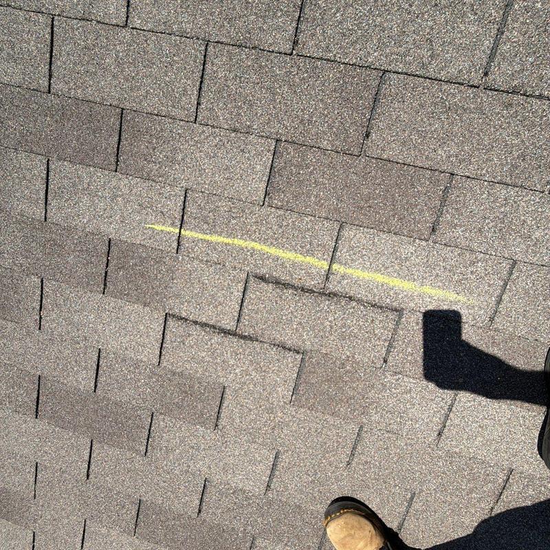 Asphalt shingles with hail damage marking on roof