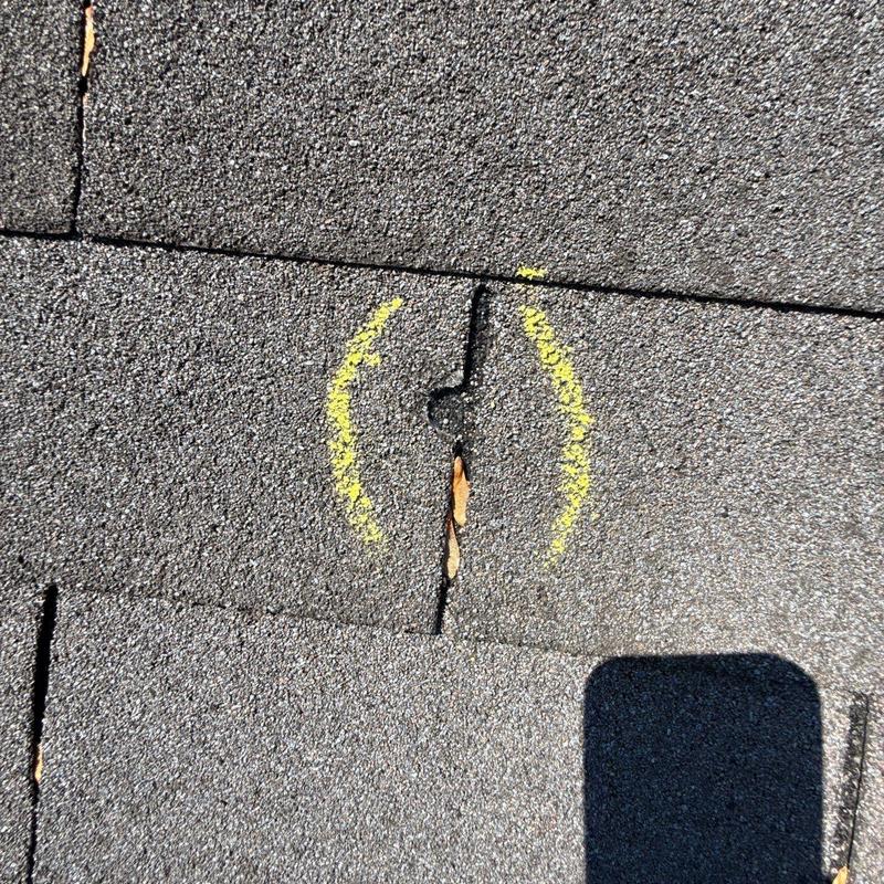 Asphalt roof shingle with crack marked for repair