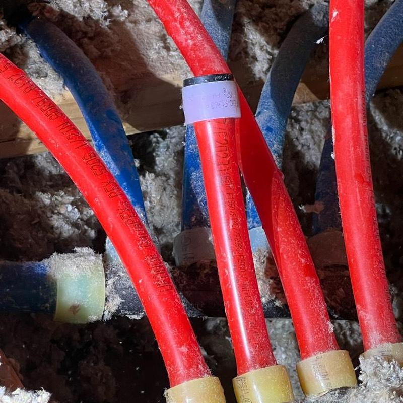 PEX piping with cap on hot side manifold in attic