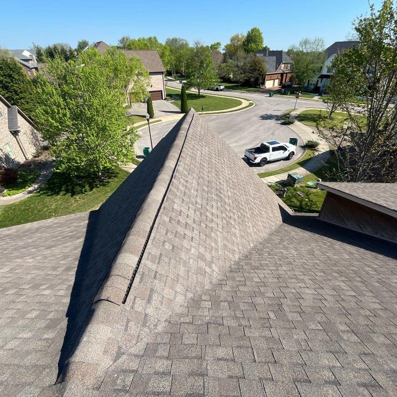Asphalt shingle roof ridge with inspection view