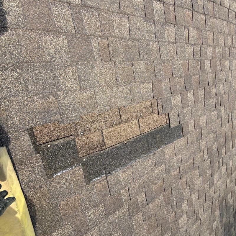 Asphalt shingles with visible hail damage and repairs