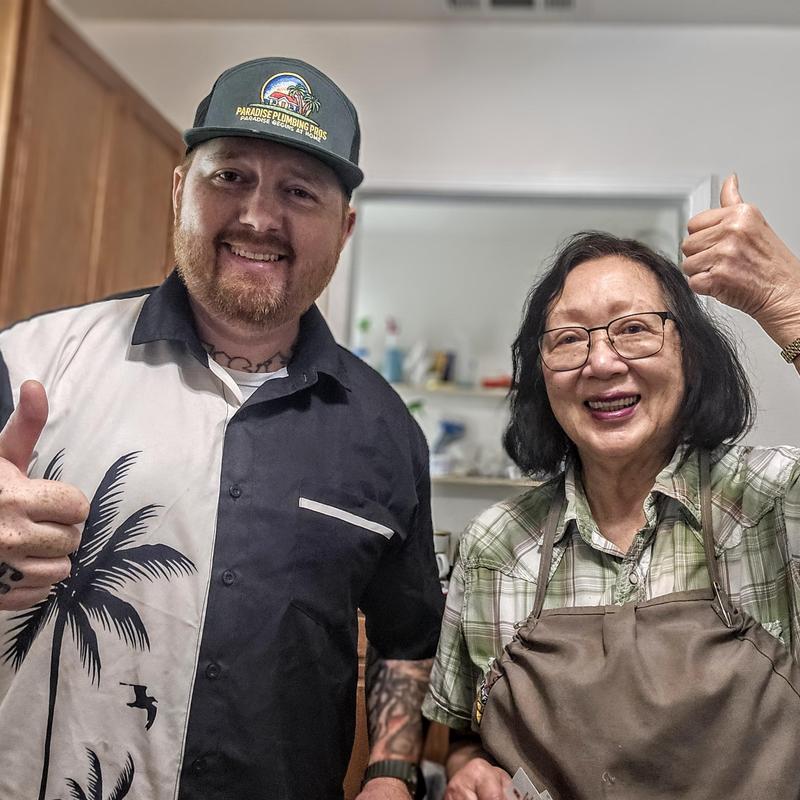 Kitchen faucet with technician and happy customer giving thumbs up