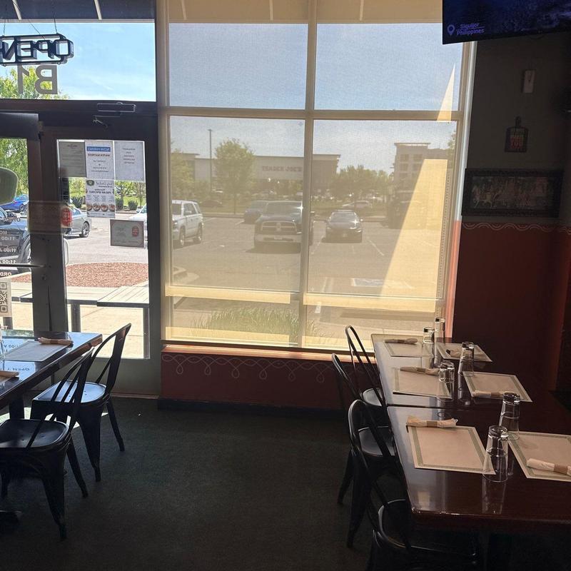 Window roller shades filtering sunlight in restaurant dining area