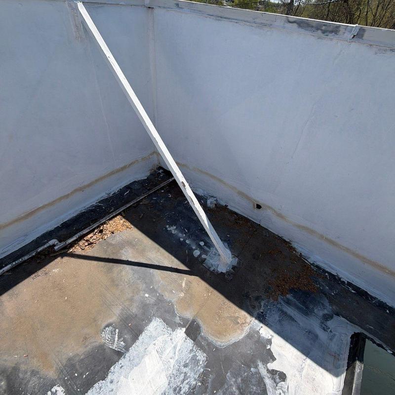 Flat roofing membrane showing weather damage and debris buildup