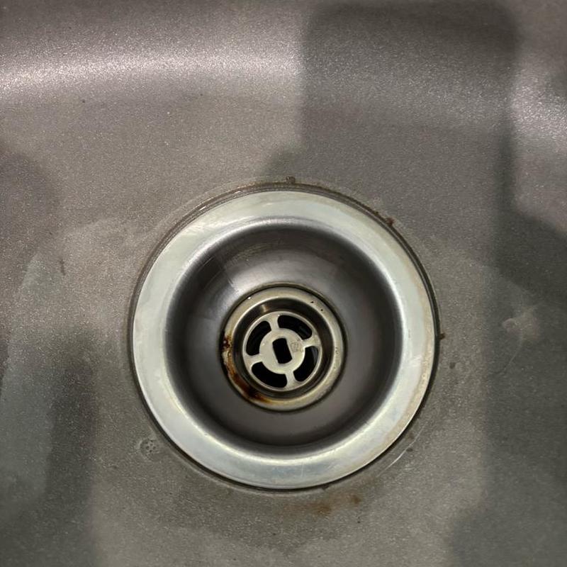 Kitchen sink with rusty metal strainer ring