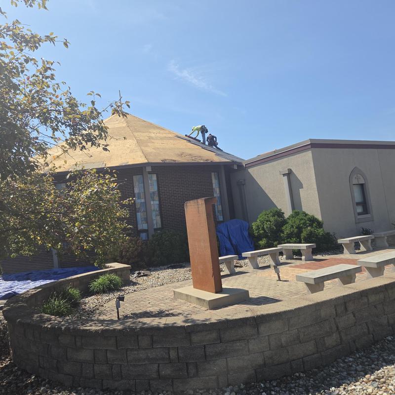 Metal roof installation on church building exterior