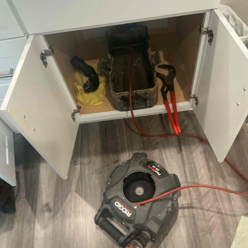 Main line plumbing with mechanical snake inside cabinet
