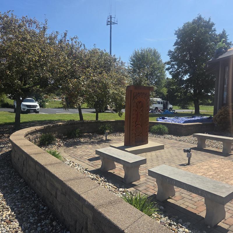 Memorial plaza with stone benches and carved monument