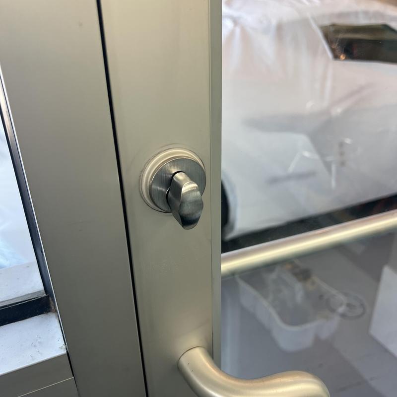 Door thumbturn lock on glass door in metal frame Door thumbturn lock on glass door in metal frame