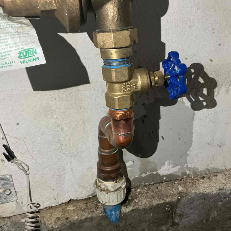 Water main shut-off valve with blue handle in garage Water main shut-off valve with blue handle in garage