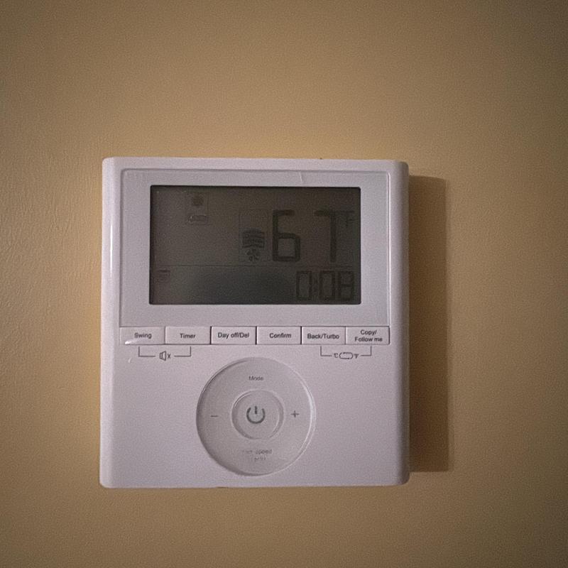 Mini-split thermostat set to 67°F on wall Mini-split thermostat set to 67°F on wall