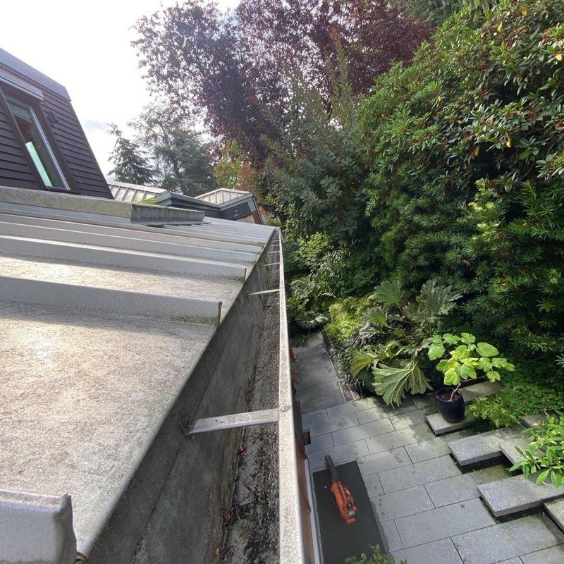 Gutter cleaning with debris removal and roof edge view