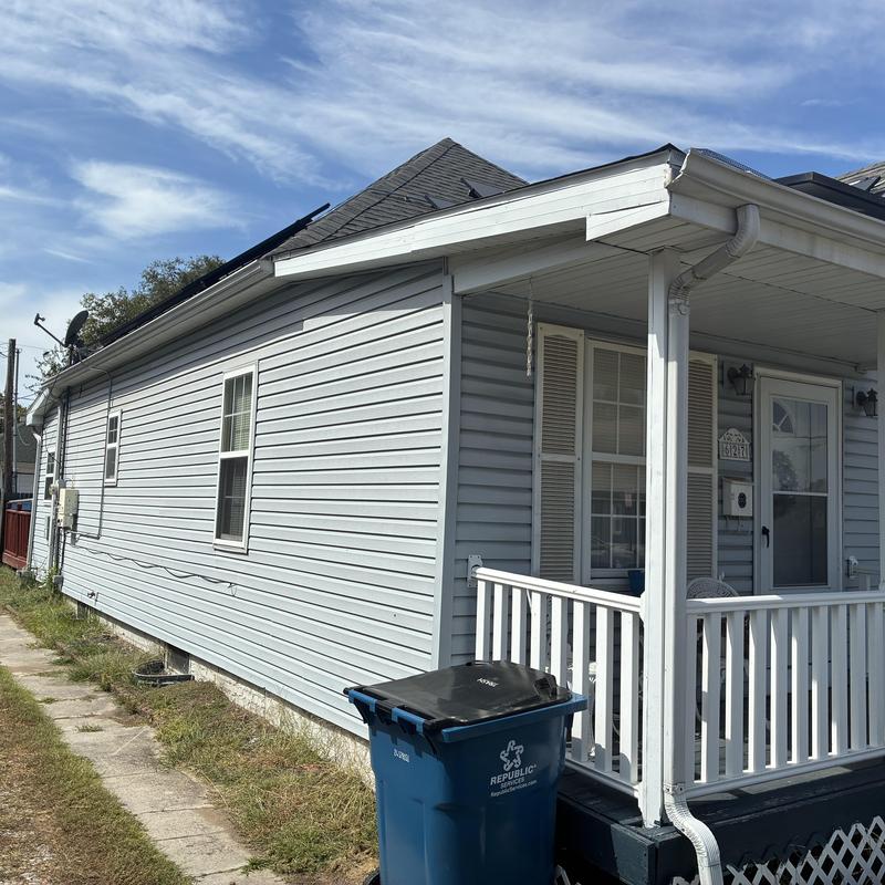 Asphalt shingle roof and white vinyl siding on house