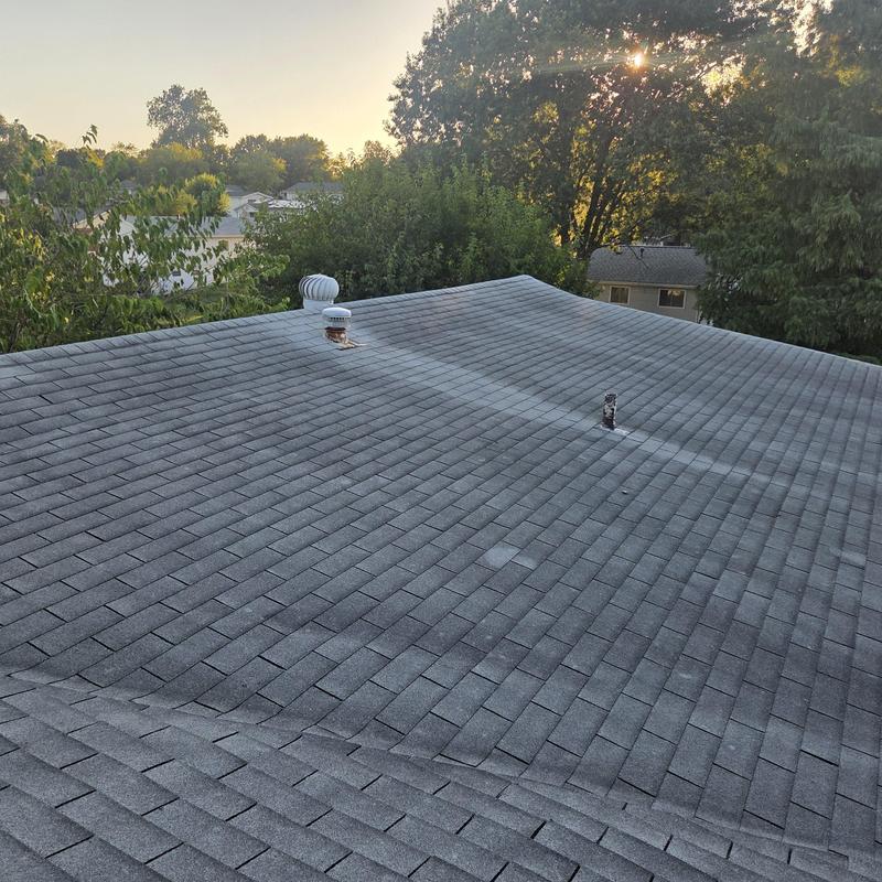 Asphalt shingle roof with vents at sunrise