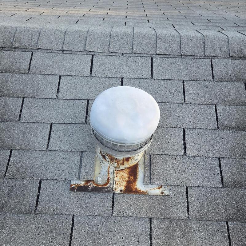 Roof vent with rusted flashing on asphalt shingles