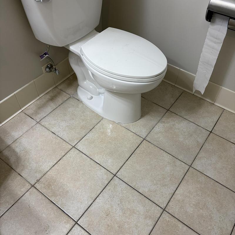 Pressure assisted toilet installation in tiled bathroom