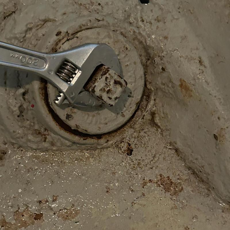 Main line cleanout cap with wrench on corroded surface Main line cleanout cap with wrench on corroded surface