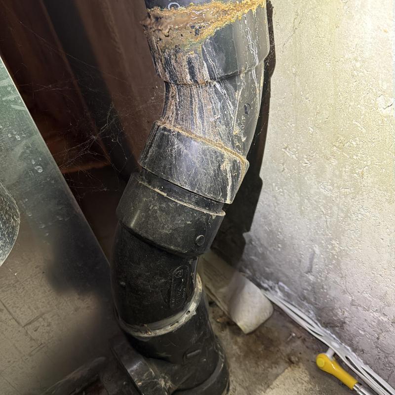 Black PVC drain pipe with corrosion buildup