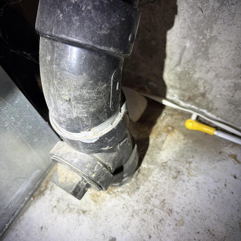 Black PVC drain pipe with joint sealant and wiring nearby