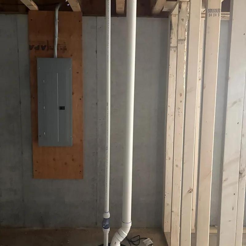 PVC drain pipes rough-in beside electrical panel in basement