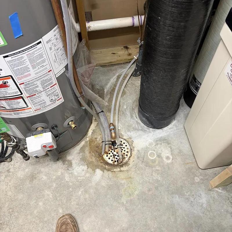Water softener with drain pipes and water heater nearby