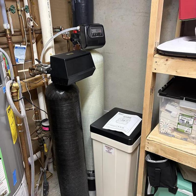 Water softener system installation in basement corner