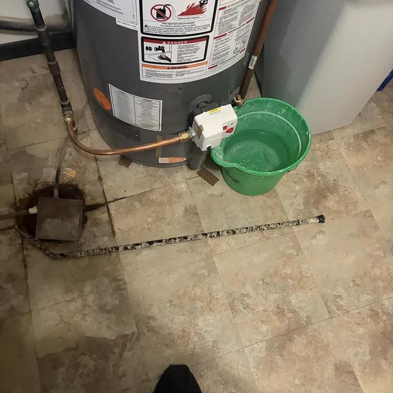 Anode rod replacement near water heater and bucket