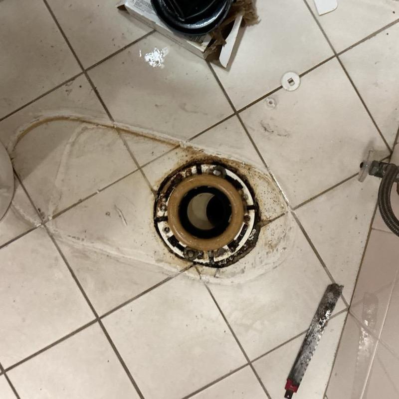 Commercial toilet flange on tiled floor before replacement Commercial toilet flange on tiled floor before replacement