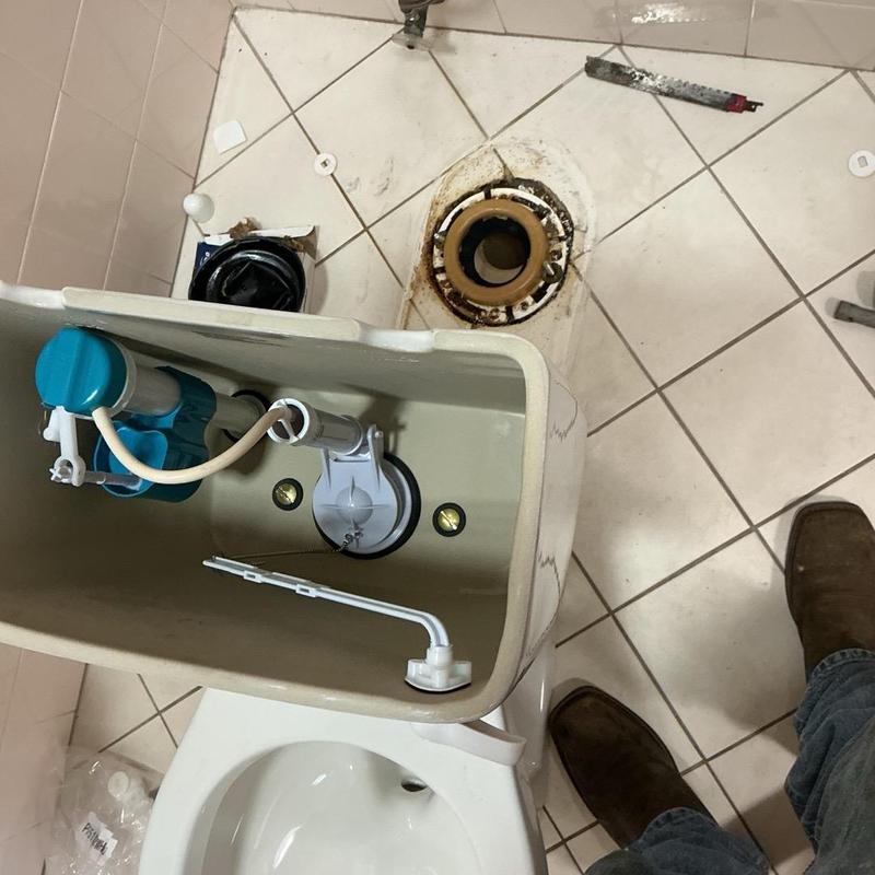 Toilet tank and flange during replacement in restroom Toilet tank and flange during replacement in restroom