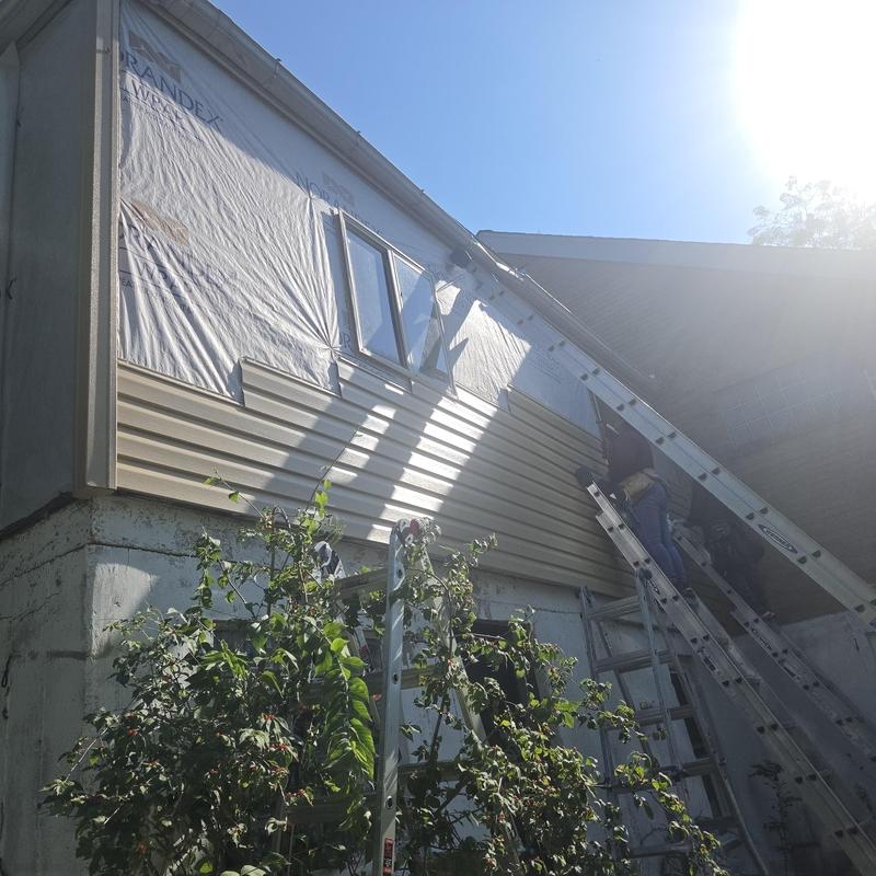 Vinyl siding installation with window and fascia wraps Vinyl siding installation with window and fascia wraps
